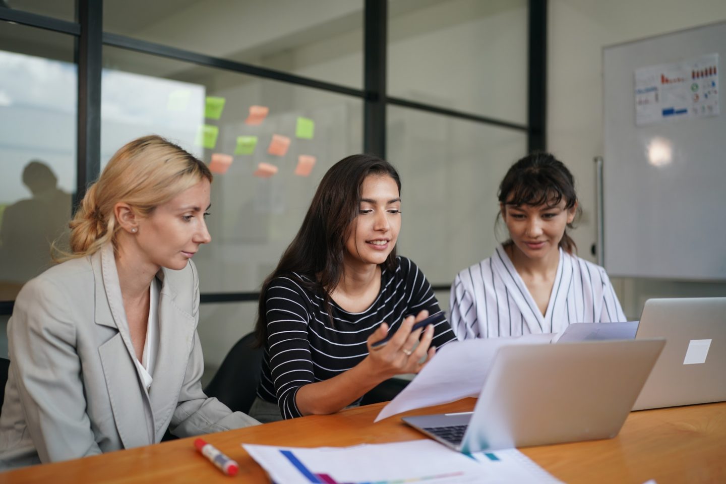 Business people have a meeting about company statistics e1699493737313